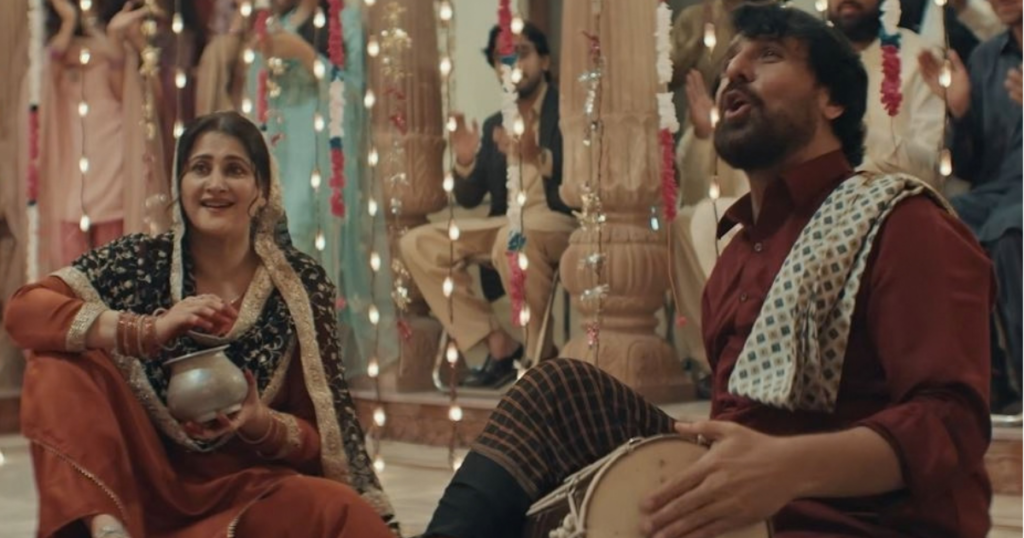 Baala's parents singing and playing dhol at an aqeeqa celebration in Mitti De Baway