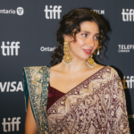 Mahira Khan smiling on the red carpet at TIFF 2026, wearing an elegant saree during her Toronto International Film Festival debut